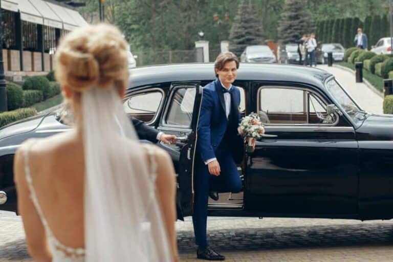 Luxury wedding couple dancing at old car in light